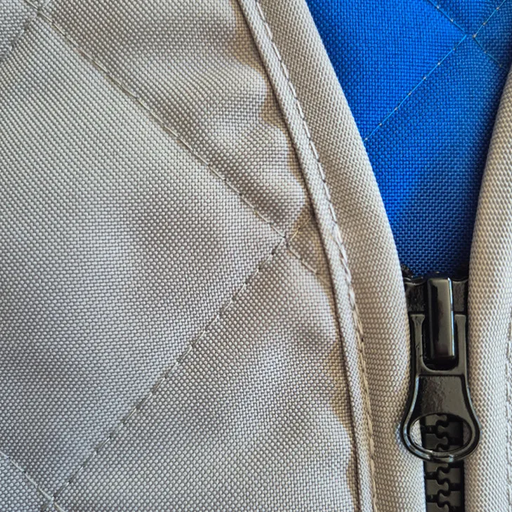 Nahaufnahme: Hochwertiger, beiger Steppstoff mit robustem, schwarzem Reißverschluss und blauer Innenseite - für Komfort & Stil.